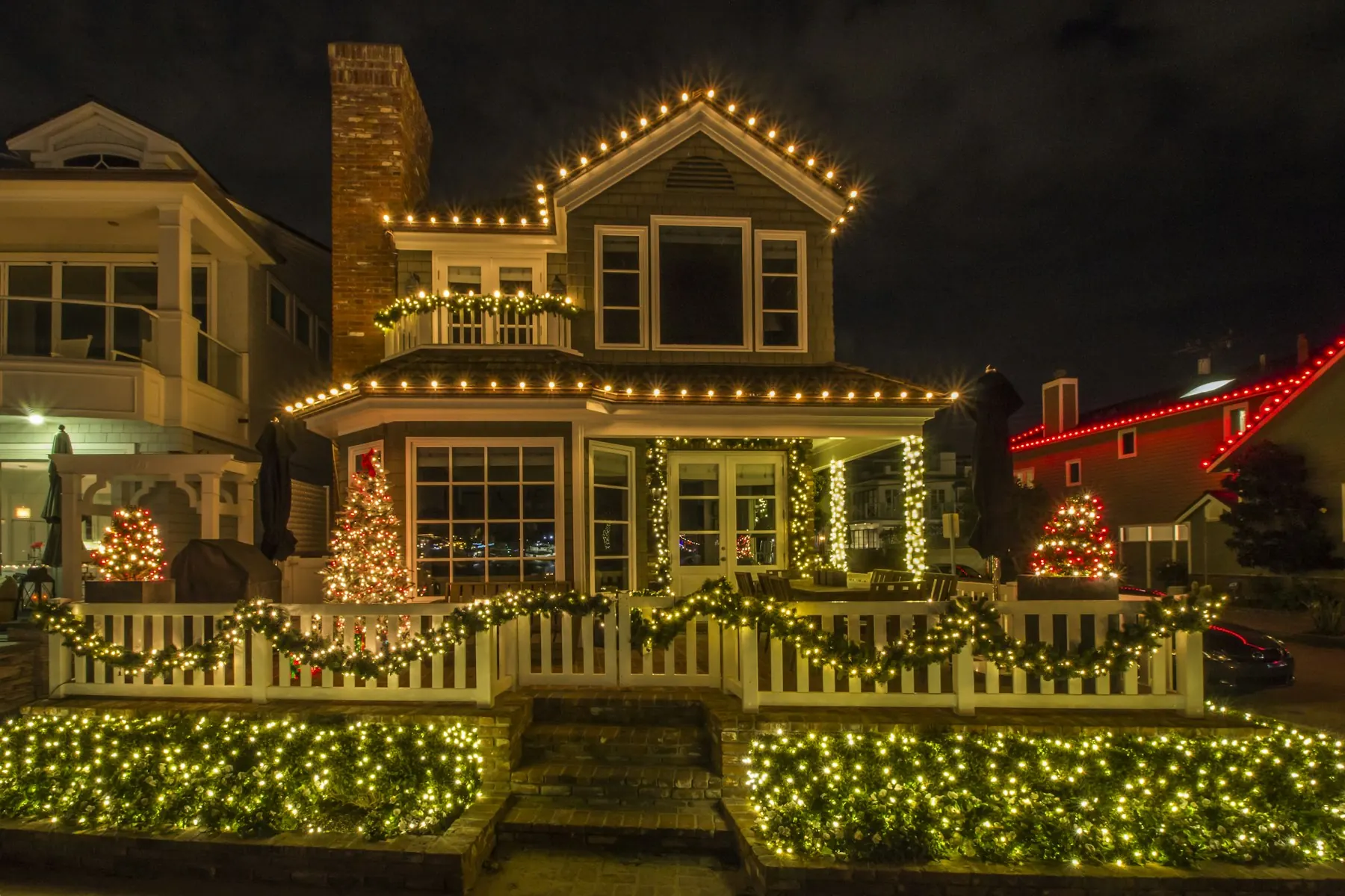 Warm white C9 lights along the roofline and porch of a house at night